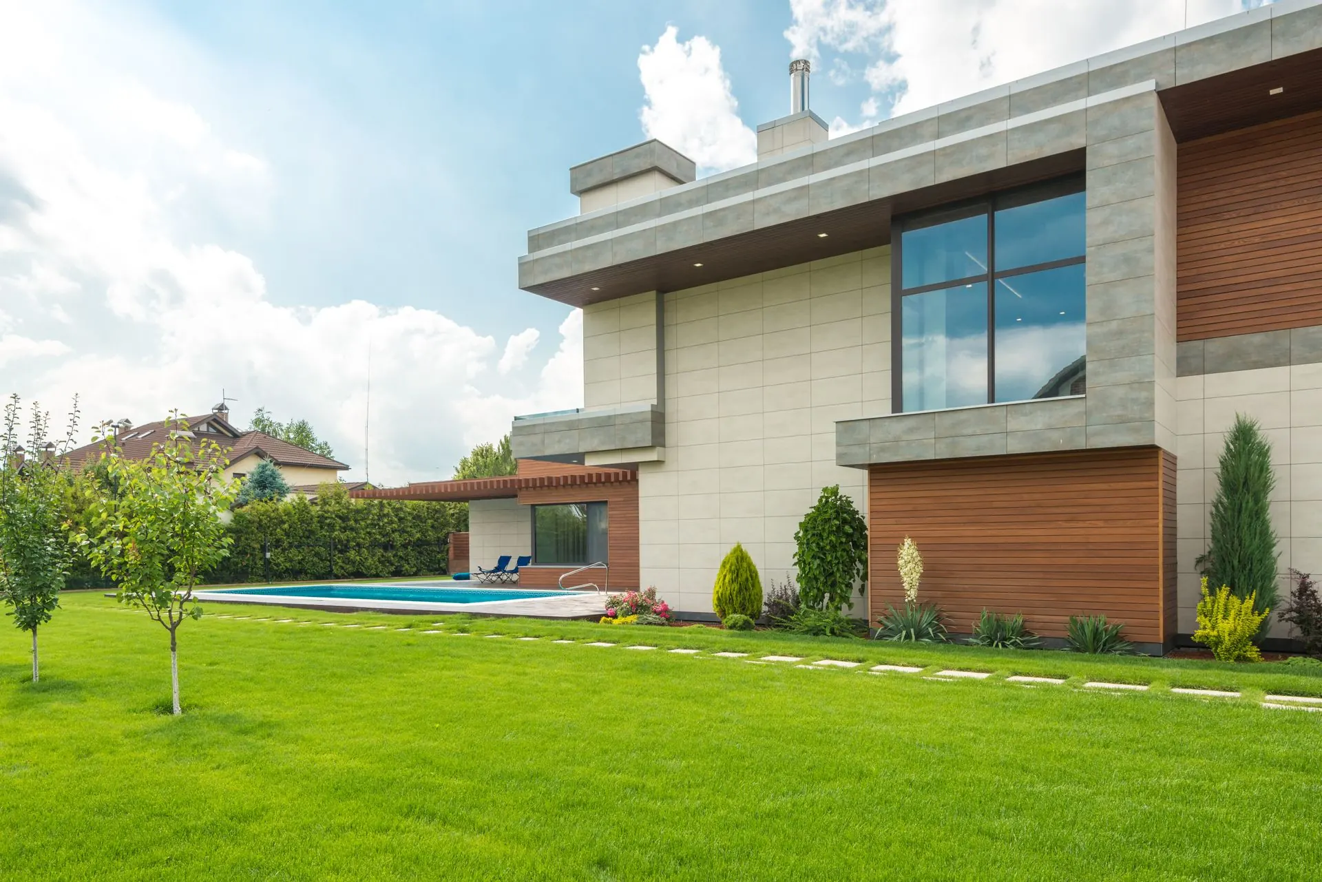 Façade de maison rénovée avec jardin entretenu, illustrant les travaux de Brunel TB à Fonsorbes